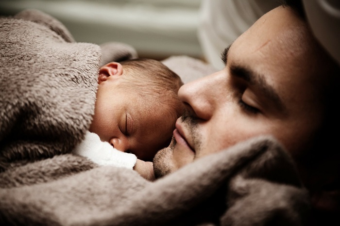 Baby schläft auf Vaters Brust