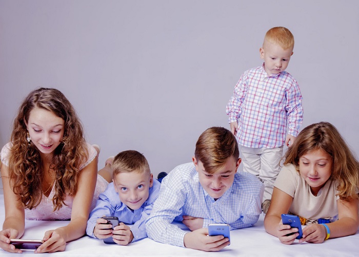 Kinder in jeder Altersgruppe sind im Handy-Fieber Kinder in jeder Altersgruppe spielen mit ihren Handys