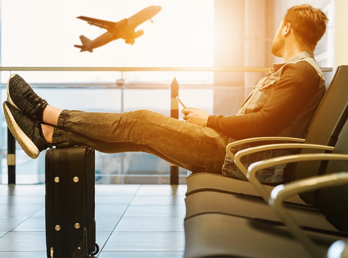 Wenn Sie bereits über drei Stunden Verspätung zu Ihrem Reiseziel haben, können Sie mit Schadensersatz rechnen Wartender Mann am Flughafen