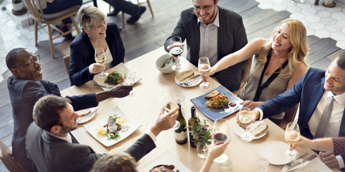 Menschen sitzen an einem Tisch und feiern