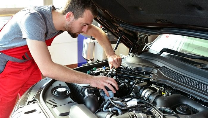 Mechaniker arbeitet am Motor eines Autos