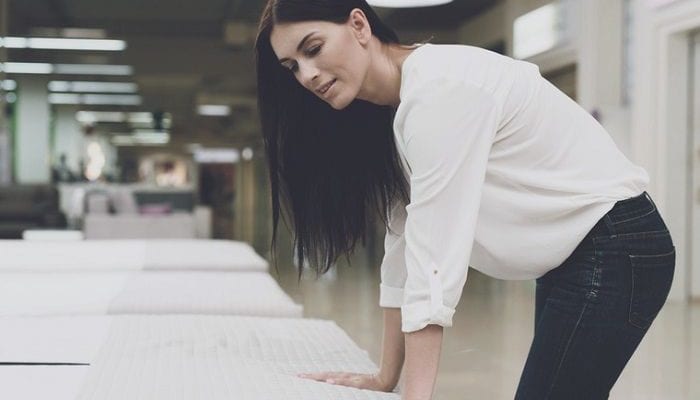 Frau testet in einem Geschäft eine Matratze