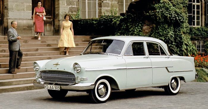 Ein lindgrüner Opel Kapitän Baujahr 1955 steht vor einem Herrschaftshaus