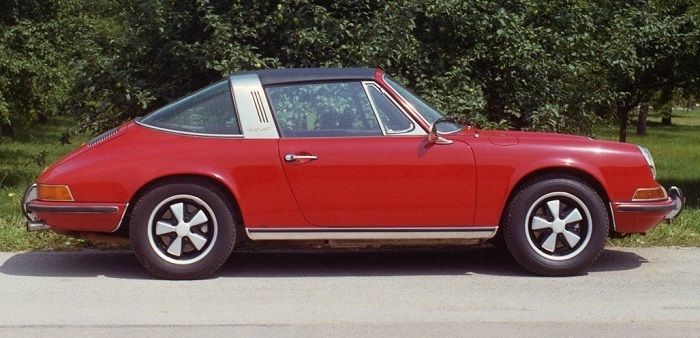 Ein roter Porsche Targa Baujahr 1972 vor einer Hecke