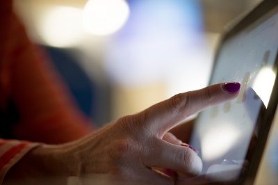 Mit einer Tablet Halterung ist das Tablet wesentlich einfacher zu bedienen Frau bedient ein stehendes Tablet