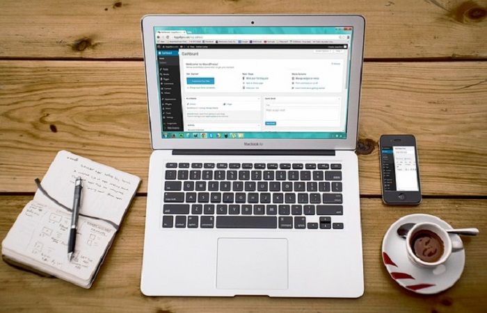 eine gut gestaltete Website hilf einem Unternehmen für mehr Online-Präsenz Tablet steht auf einem Holztisch