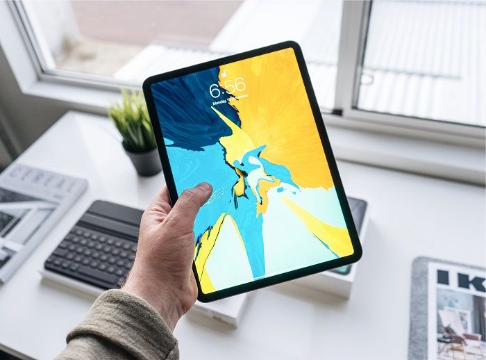 Ein Tablet bietet viele praktische Anwendungen und wird so zum ständigen Begleiter Jemand hat ein Tablet in der Hand