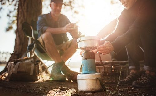 Ein Paar kocht in freier Natur mit dem Gaskocher