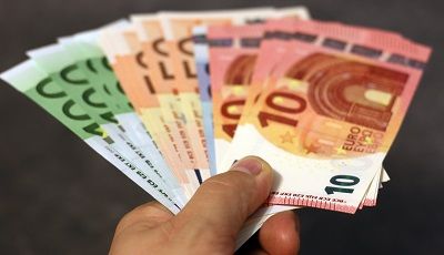 Bei Minikrediten sollten einige Dinge immer beachtet werden Geldscheine gefächert nach Größe in der Hand liegend
