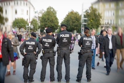 Polizisten stehen vor Passanten die zur Wiesn wollen 