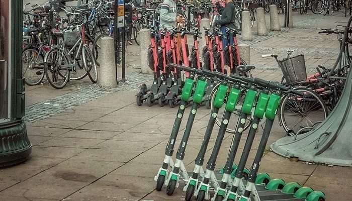 Viele E-Scooter stehen auf einem Platz in einer Stadt