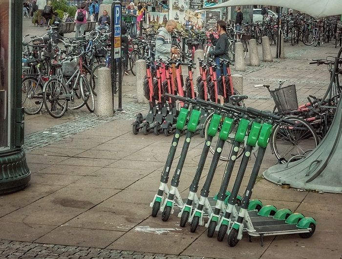 Viele E-Scooter stehen auf einem Platz in einer Stadt