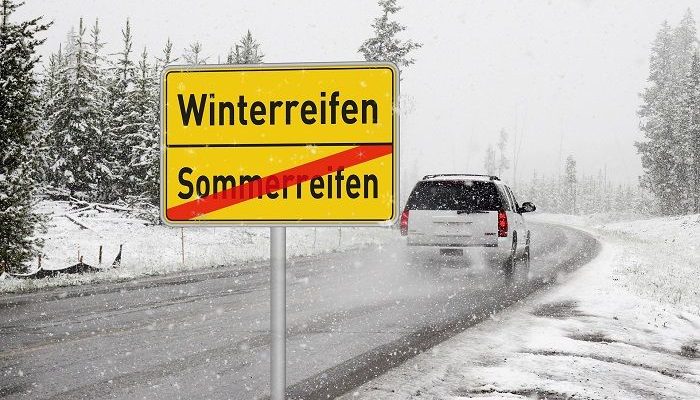 Auto fährt auf Straße in winterlicher landschaft