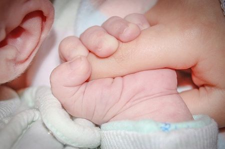 Baby hält den Finger vom Vater