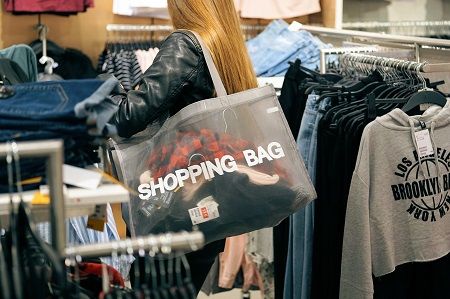 Frau kauft mit einer shopping bag ein