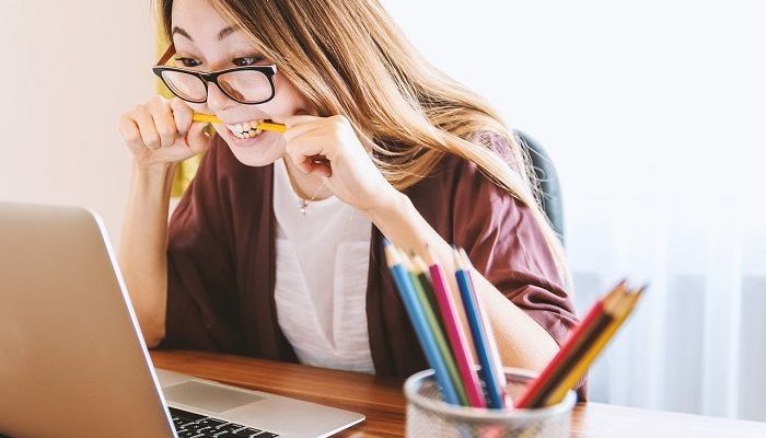 Frau beißt auf einen Bleistift