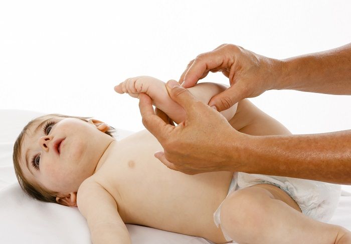 Ein Osteopath behandelt ein Baby am Bein