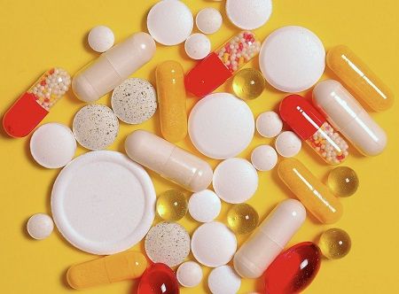 Verschiedenste Pillen in großer Menge liegen auf einem Tisch