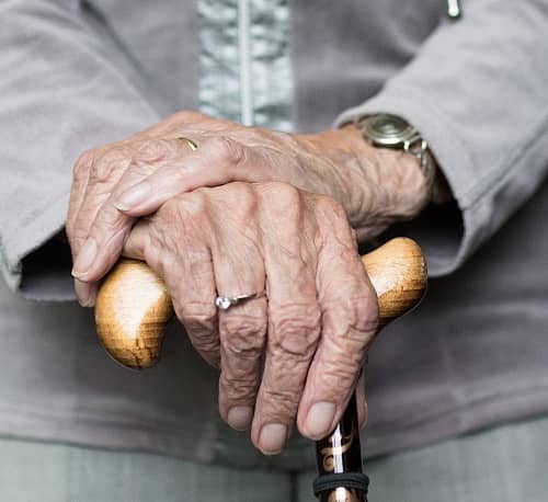 Alte Frau stützt sich auf Ihren Gehstock