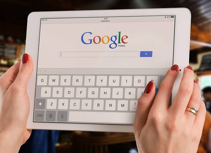 Frau hält ein Tablet in der Hand, die Google Suchmaske ist zu sehen