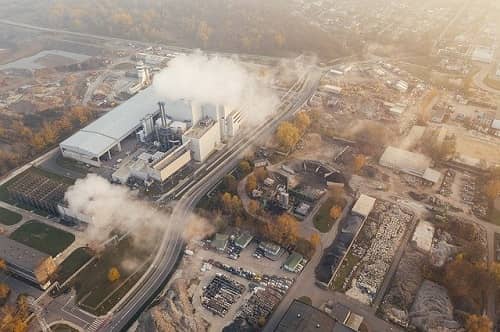 Eine Stadt mit Industrie und viel Rauch von oben gesehen