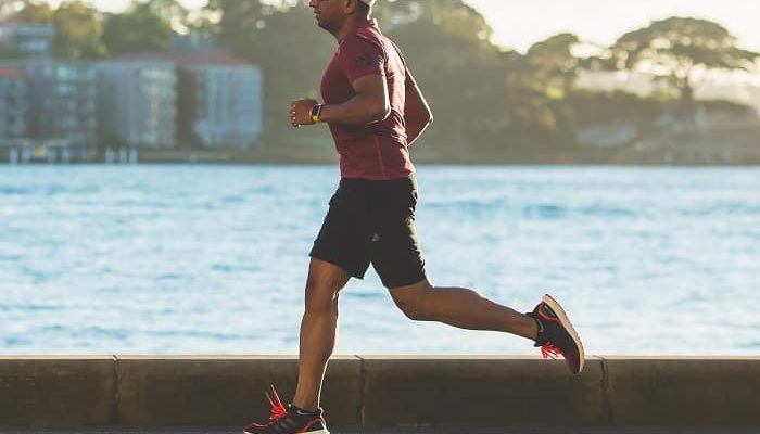 Mann joggt auf einer Strasse am Meer