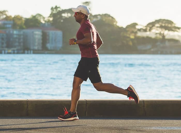 Mann joggt auf einer Strasse am Meer 