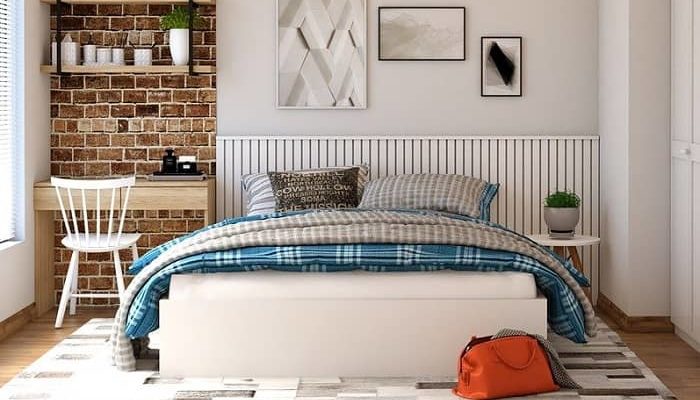 Schlafzimmer mit einem weißen Bett und blaukarierter Bettwäsche