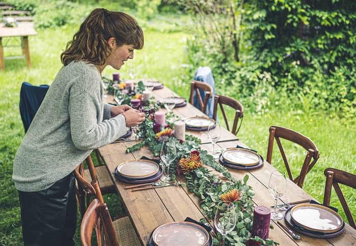 Franziska Braun dekoriert gerade einen alten Holztisch mit Blumendekoration