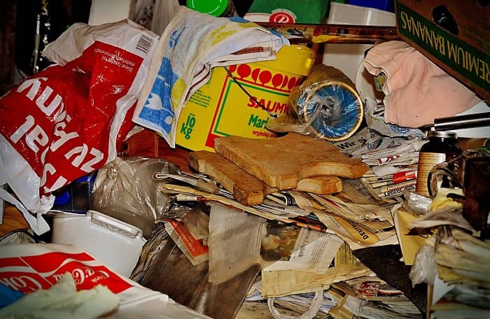 Anblick auf eine Messi Ecke, unordendlich gestappeltes Zeug, Plastikeimer, Zeitungen, Toastbrote usw.