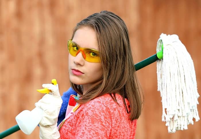 Junge Frau mit verschiedenen Putzutensilien