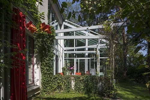 Eine große Terrasse mit Glas und weißem Aluminium überdacht