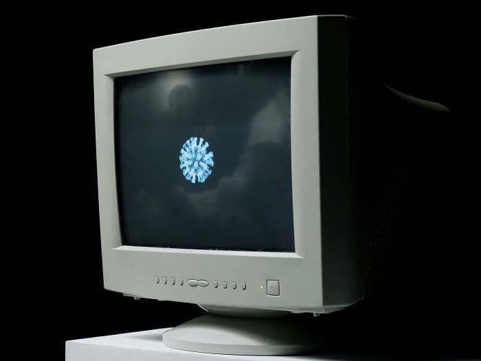 Ein Bildschirm zeigt mittig einen Corona Virus