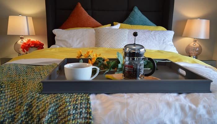 Ein dekoratives Bett, mit einem Tablett und Frühstück darauf
