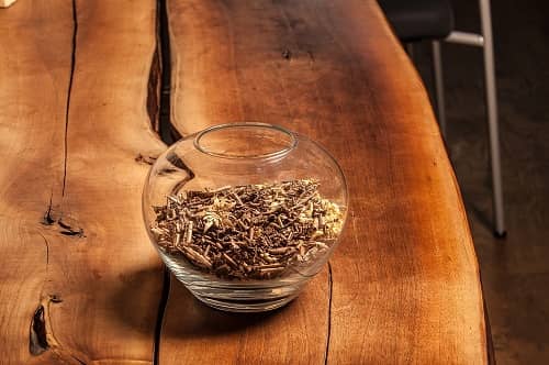 Ein Holztisch auf dem eine Glasschale mit Holzspänen steht