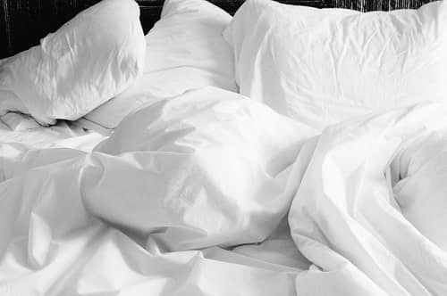 Verschieden große Kissen in weißer Bettwäsche