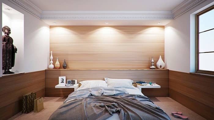 Ein schönes helles Schlafzimmer mit Kunstgegenständen und einem ungemachten Doppelbett
