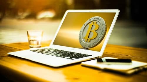 Ein Laptop, auf dem eine Bitcoin Münze zu sehen ist
