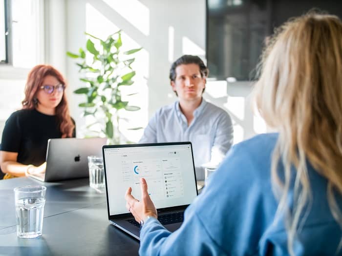 Zwei Frauen und ein Mann, sitzen in einem Büro und nehmen an einer Schulung teil