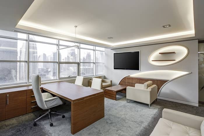 Ein helles modern eingerichtetes Büro mit perfekt aufeinander abgestimmten Möbeln, vor einem großen Fenster
