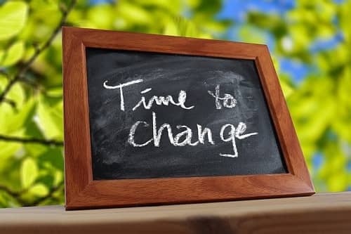 Eine Tafel mit dem Text "Time to change" steht auf einer Brüstung im Freien