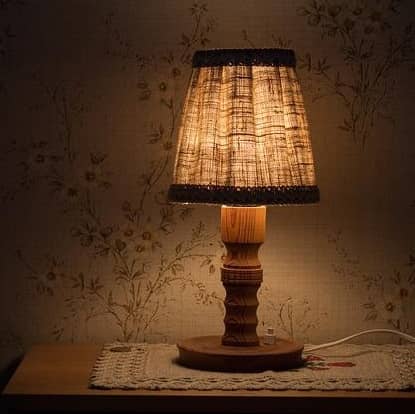 Eine nostalgische Schlafzimmer Nachttischlampe steht auf einem Nachtkästchen