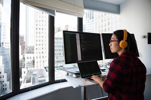 Eine Frau arbeitet am Laptop in einem Hochhaus Büro