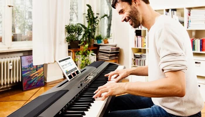 Mann spielt im Wohnzimmer Klavier