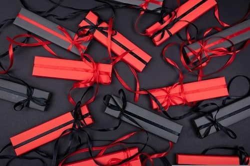 Viele verpackte Geschenke alle in rotem oder schwarzem Geschenkpapier