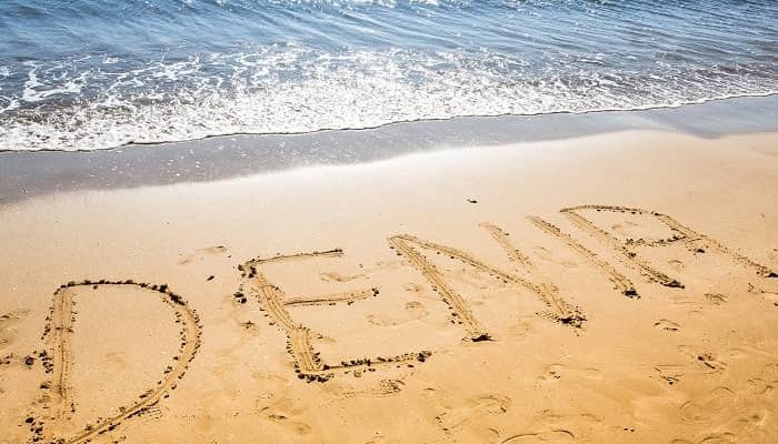 Das Wort Dénia in den sand am Strand geschrieben