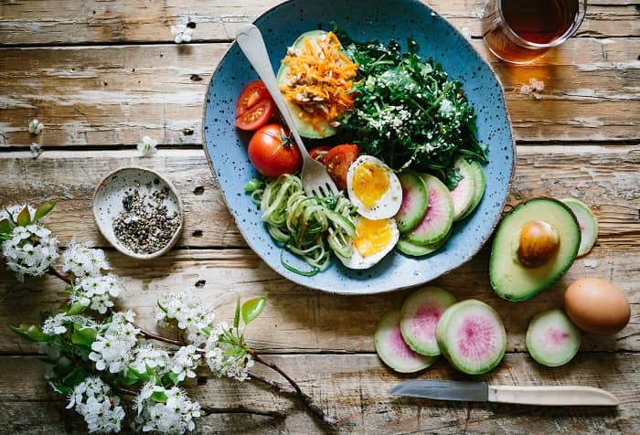 Eine Schüssel mit Gemüse und Salat, steht mit einer Gabel auf dem Tisch