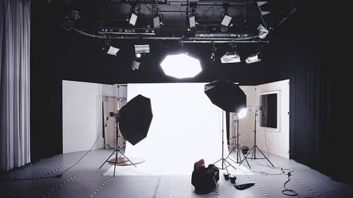 Man sieht ein aufgebautes Fotostudio mit hellem Licht ausgeleuchtet