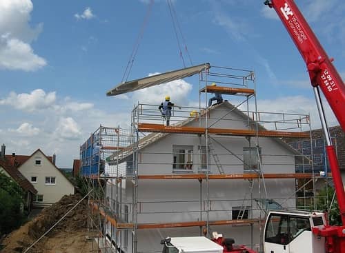 Man sieht ein Haus mit einem Gerüst, an dem gerade gebaut wird