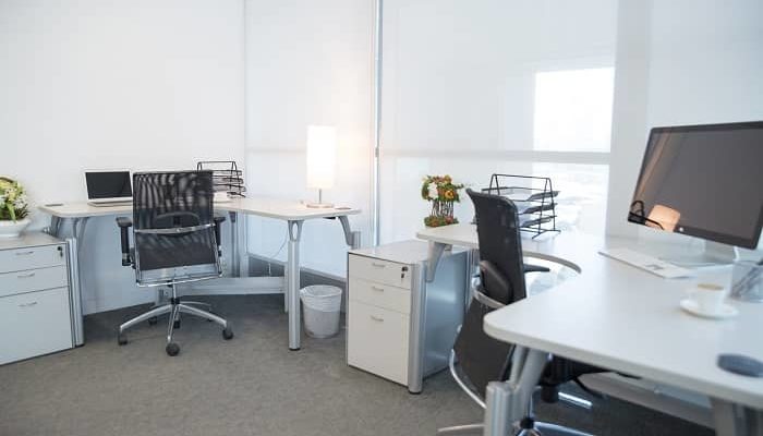 Ein helles Büro mit zwei Schreibtischen und zwei bürodrehstühlen